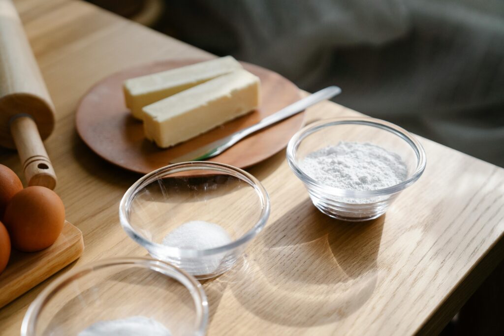 Close-up of baking ingredients on a wooden table with natural lighting.