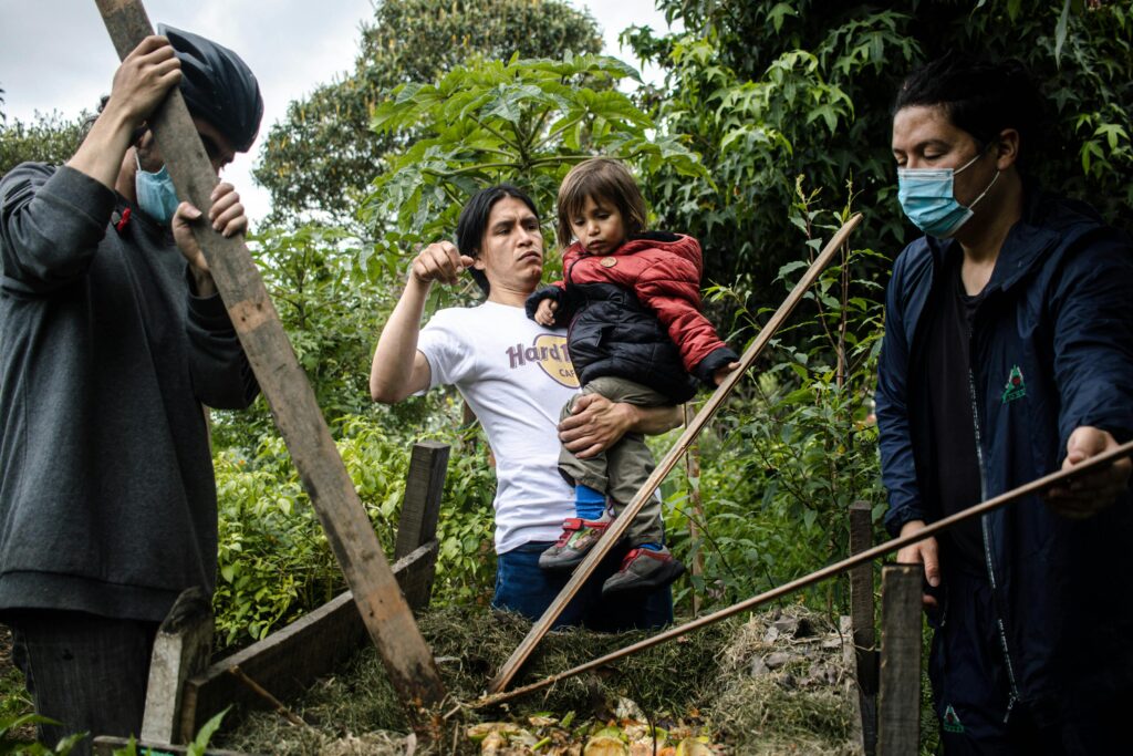 Family tending a garden in Bogotá, Colombia, showcasing teamwork and sustainability.