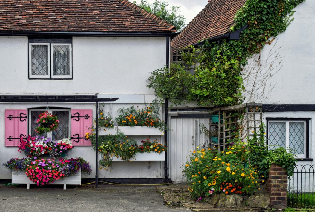Picturesque English cottage facade adorned with colorful flowers and lush greenery in Eynsford.
